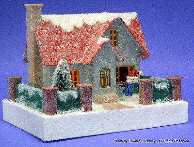 This 'putz' house is a Howard Lamey creation, inspired by the 'hero boy's' home in the Polar Express movie, one of countless examples you can find in our Cardboard Christmas discussion forums, many of which have published patterns. Click for bigger photo.